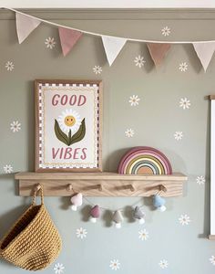 there is a wooden shelf on the wall with flowers and a good vibes sign above it