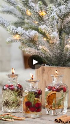 three glass bottles filled with different types of liquid next to cinnamon sticks and pine cones