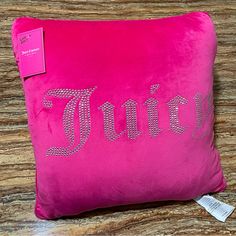 a pink pillow with the word juicy on it and a tag hanging from the side