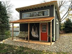 a small house with a hammock hanging on the front door and porch attached to it