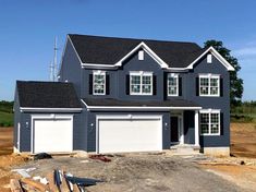 a house under construction with two garages and three windows