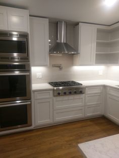 a kitchen with white cabinets and stainless steel appliances