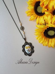 Imagine this pretty "Sunflower Embroidery Necklace" on You or loved ones which is made with love and passion! This handmade stylish custom necklace with tiny sunflowers and green leaves in bronze oval elegant 6 alternative pendants: - Hand embroidered by a technique called "Brazilian embroidery". Each little detail is crafted individually by hand using a tiny needle. - Has measurements of approx.:   Adjustable necklace length: 27 Inches (70 cm); Pendant height: 2 Inches (5 cm), width: 1.6 Inches Sunflower Embroidery, Hand Embroidered Jewelry, Wristwatch Vintage, Hoop Necklace, Embroidery Necklace, Embroidered Jewelry, Floral Pendant Necklace, Daisy Jewelry, Small Makeup Bag