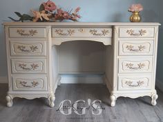 an antique white desk with flowers on top