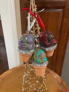 three pots with decorations on top of a wooden table