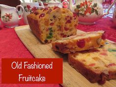 an old fashioned fruitcake is cut into slices on a cutting board with teapots in the background