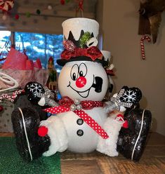 a large snowman sitting on top of a wooden table