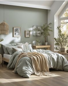 a bedroom with green walls and wooden flooring has a large bed in the middle