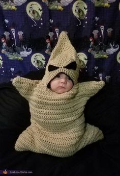 a baby wrapped in a crochet costume