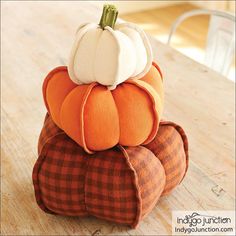 three pumpkin pillows stacked on top of each other