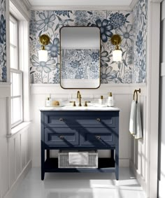 a bathroom with blue and white floral wallpaper, two sinks and a large mirror