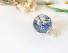 "I have very carefully treated these beautiful blue forget me nots to retain their lovely color then set in crystal clear, eco friendly resin. These lovely little flowers are always a favourite for any flower lover and make the perfect gift to show your undying true love always. Little flowers encapsulated forever and ever... The large orb measures around 25mm, (approx 1\") I have capped with a pretty silver cap, options available the sterling silver chain is 18\" chain or longer 30\" chain for Blue Flower Charm Necklace As Gift, Blue Flower Pendant Necklace For Gift, Blue Flower Necklace For Gifts, Blue Flower Necklace Gift, Blue Pressed Flower Necklace, Blue Flower Necklace With Birth Flower Detail, Blue Birth Flower Necklace For Gift, Blue Birth Flower Necklace Gift, Blue Flower Necklace For Wedding