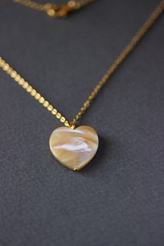 This delicate unique necklace was made of natural mother of pearl beige heart pendnat and high quality gold tone stainless steel chain with gold tone lobster claw. The chain is from lead & nickel free metal. Perfect jewelry for everyday wear and a great gift for someone special! The length of necklace is 45 cm or 17.7 inches. Other necklaces of my shop you can see here: https://www.etsy.com/shop/NaTavelli?section_id=14843046&ref=shopsection_leftnav_5 Thanks for a visit. Gold Necklaces With Gemstone And Mother Of Pearl, White Gemstone Necklace With Mother Of Pearl, Gold Necklace With Gemstone And Mother Of Pearl, Gold Mother Of Pearl Necklace With Gemstone, Shell Necklace With Round Pendant As A Gift, Gift Shell Necklace With Round Pendant, Minimalist Handmade Heart Pendant Necklace, White Spiritual Shell Necklace As A Gift, Spiritual White Shell Necklace Gift