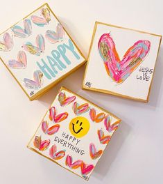 three handmade greeting cards with painted hearts and the words happy, love, and everything