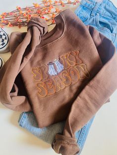 The cutest new edition to the shop! A Spooky Season Western Ghosts Embroidered design on a Hanes Eco Smart/ Gildan Crewneck. Cute Floral Embroidery Fall Tops, Brown Fall Sweatshirt With Embroidered Logo, Brown Sweatshirt With Embroidered Logo For Fall, Retro Tops With Embroidered Logo For Fall, Cute Custom Embroidered Tops For Fall, Cute Tops With Custom Embroidery For Fall, Trendy Tops With Custom Embroidery For Fall, Retro Embroidered Sweatshirt For Fall, Cute Embroidered Text Tops For Fall