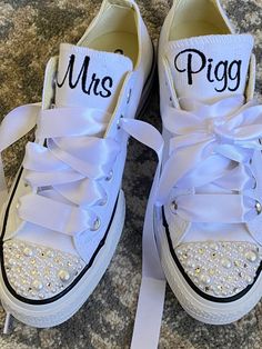 a pair of white shoes with the word mrs piggie written on them, tied together