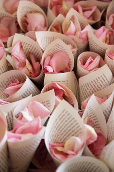 some pink flowers that are on top of an open book page with the words pint