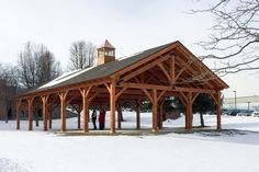 two people standing in the snow under a covered pavilion