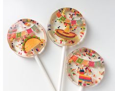 three candy lollipops decorated with colorful confetti and mexican hats on them