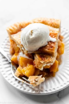 a piece of pie on a white plate with a scoop of ice cream on top