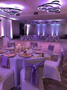 a banquet room set up with purple and white decor