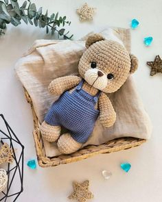 a crocheted teddy bear sitting on top of a pillow