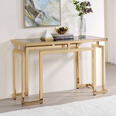 a console table with two vases on it in front of a painting and rug