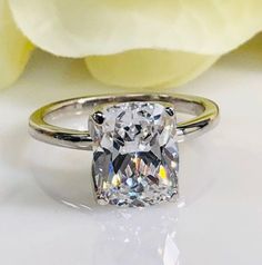 Elongated cushion cut engagement ring, 3.00 ct, 14k white gold #5458 #EthicallySourced #SquareRing #ClassicRing #BrilliantCut #FreeShipping #AnniversaryRing #DiamondAlternative #14kWhiteGoldRing #WeddingRings #DiamondEngagement Classic Silver Topaz Ring With Radiant Cut, Classic Radiant Cut Anniversary Rings, Modern Cushion Cut Rings With Accent Stones, Classic Radiant Cut Wedding Rings, Anniversary Solitaire Ring With Radiant Cut, Rectangular Diamond Ring With Accent Stones For Wedding, Radiant Cut Ring With Accent Stones For Anniversary, Rectangular Silver Ring For Wedding, Silver Rectangular Wedding Ring