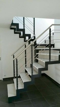 there is a black and white stair case in the room with tile flooring on the ground