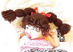 a doll with curly hair laying on top of a bed