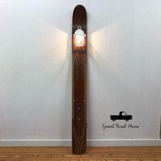 a snowboard mounted to the side of a wall with a light on it's end