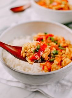 a spoon full of food with rice and sauce