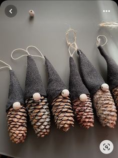 five pine cone ornaments are lined up in a row on a table with twine string