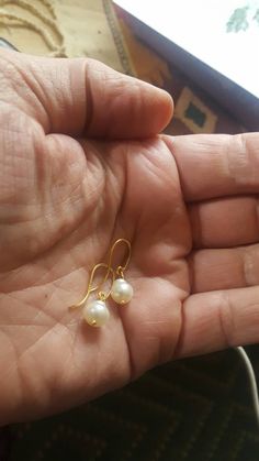 Another simple style in my category of pure gold earrings for sensitive ears. Great if you want small earrings that still have a lot of pizazz... The little pearl dangle moves gently and really is quite charming. Because these are small earrings, less than an inch in overall length, they stay out of the way while looking great! I matched two button shaped cultured fresh water pearls (one tiny and one about 5mm in diameter) and put them on a pure 24K gold wire dangle. Then I attached them to a gr Pure Gold Earrings, Earrings For Sensitive Ears, Pearl Dangle Earrings, Water Pearls, Pearl Earrings Dangle, Gold Hands, Small Earrings, Gold Wire, Pure Gold