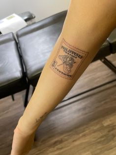 a person with a tattoo on their arm and leg is standing in front of a chair