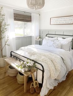 a bed with white sheets and pillows in a bedroom next to a wooden flooring