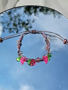 a close up of a car mirror with beads and flowers on it