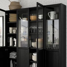 an open cabinet with dishes and cups in it