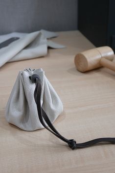 a white bag sitting on top of a wooden table next to a pair of scissors