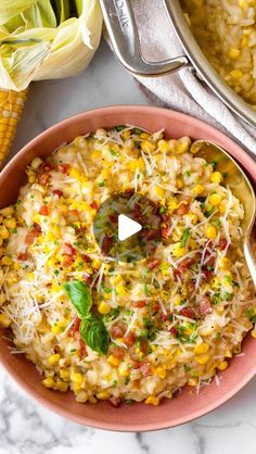 a bowl filled with corn and cheese on top of a table next to other dishes