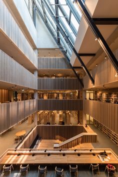 the interior of a large library with lots of bookshelves and tables in it