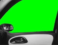 the interior of a car with a green screen in the side view mirror on it