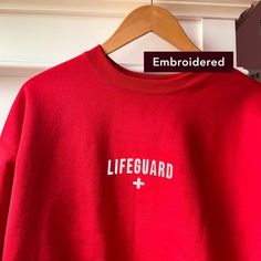 "\"Lifeguard\" embroidered on a comfy vintage-style crewneck. If you're on the lookout for both style and comfort, this fleece sweatshirt is the perfect choice. And with up to 5% recycled polyester in components, you'll be taking a little step closer to a more earth-friendly way of life. * Sizes are unisex * 50% cotton, 50% polyester (up to 5% recycled polyester, made from plastic bottles) * Fabric weight: 7.8 oz/y² (264.5 g/m²) * Patented low-pill, high-stitch density PrintPro® XP fleece * Doub Casual Crew Sweats With Embroidered Logo, Relaxed Fit Crew Sweater With Embroidered Logo, Crew Neck Sweatshirt With Embroidered Logo, Crew Sweater With Embroidered Logo For Loungewear, Hoodie With Embroidered Logo For Loungewear, Crew Neck Sweater With Embroidered Logo For Loungewear, Relaxed Fit Sweatshirt With Embroidered Logo Crew Neck, Oversized Crew Neck Sweatshirt With Embroidered Logo, Loungewear Hoodie With Embroidered Logo