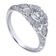 a white gold engagement ring with an oval center surrounded by round diamonds