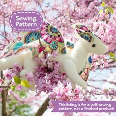 a stuffed animal sitting on top of a tree filled with pink flowers next to a text overlay that reads sewing pattern