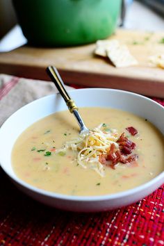 a bowl of soup with cheese and bacon in it