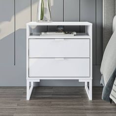 a white night stand with two drawers and a flower vase on the nightstand next to it