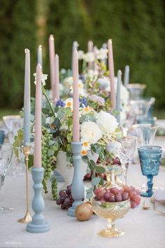 a table topped with lots of candles and flowers