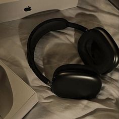 an apple computer and headphones on a bed