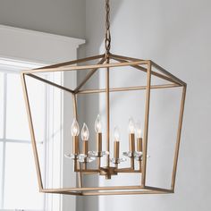 a chandelier hanging from the ceiling in a room with white walls and windows